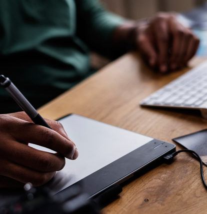 a person using a drawing tablet connected to a computer