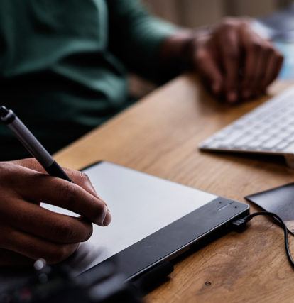 a person using a drawing tablet connected to a computer